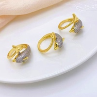 Cincin perhiasan statement chunky untuk wanita, dengan desain band emas melengkung yang saling menyatu dan band kristal pave.