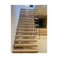 Escalier à monopoutre en acier découpé au laser, montantes ouvertes, marches en noyer, main courante minimaliste
