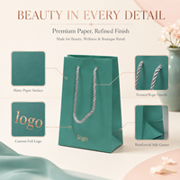 Sac cadeau en papier bleu sarcelle personnalisé avec poignées en corde torsadée et pelliculage mat pour l'emballage de cosmétiques, de parfums et de produits de spa