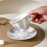 Ensemble de tasses à café et soucoupes en céramique élégantes, de style moderne, durables, écologiques, à rayures contrastées rose-bleu, avec bordure dorée, personnalisables