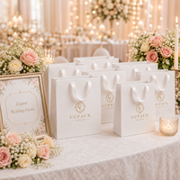 Sac en papier cartonné blanc personnalisé avec poignée en ruban, logo en feuille d'or, finition mate pour l'emballage de vêtements de boutique, vente en gros
