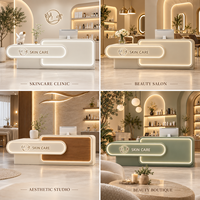 Comptoir d'accueil moderne pour salon de beauté, beige crème, asymétrique, double couche, façade arrondie avec éclairage LED chaud pour hall de spa