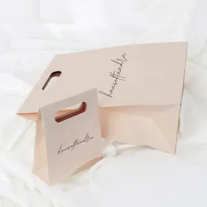 Emballage de perruque design avec poignées découpées imprimé de logo personnalisé sacs en papier kraft de parfum fantaisie de qualité supérieure en rose