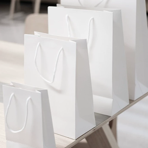 Sacs cadeaux en papier kraft blanc imprimés sur mesure pour emballages promotionnels d'entreprise avec logo et ruban de poignée - Product Image 1