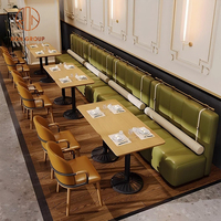 Ensemble de meubles modernes pour café, restaurant, salon de thé : canapés incurvés verts, tables rondes en bois et chaises oranges