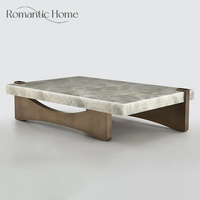Table basse élégante et minimaliste de luxe en marbre naturel avec base arquée en bronze pour hôtel de luxe, hall d'entrée ou salon.