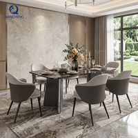 Ensemble de table à manger de luxe avec 6 chaises, plateau en marbre noir, base en acier foncé en forme de V, fauteuils en tissu PU, style Japandi, villa, vente en gros, usine OEM