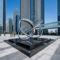Sculpture circulaire abstraite en acier inoxydable plaqué argent poli miroir, design tendance pour jardin extérieur et piscine