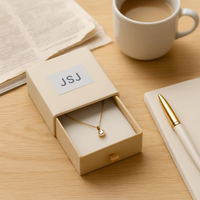 Boîte cadeau de luxe noire mate avec logo doré pour présentation haut de gamme de bagues et boucles d'oreilles