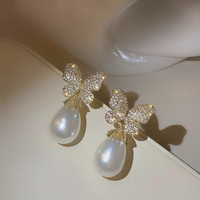 Les nouvelles boucles d'oreilles en alliage de perles d'imitation papillon sont élégantes, faciles à assortir et à la mode avec des strass