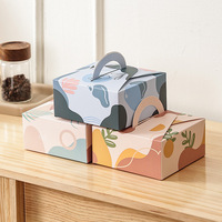 Boîte d'emballage de pâtisserie tenue dans la main, boîte de gâteau, boîte de produits de boulangerie