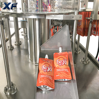 Machine de remplissage et de bouchage rotative XF entièrement automatique à double entraînement contrôlée par PLC pour sachets à bec verseur, remplisseuse de liquides et de pâtes Doypack