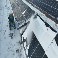 Brosse de nettoyage de panneaux photovoltaïques montée sur chargeur avec système de pulvérisation pour le nettoyage des poussières et l'élimination de la neige dans les fermes solaires