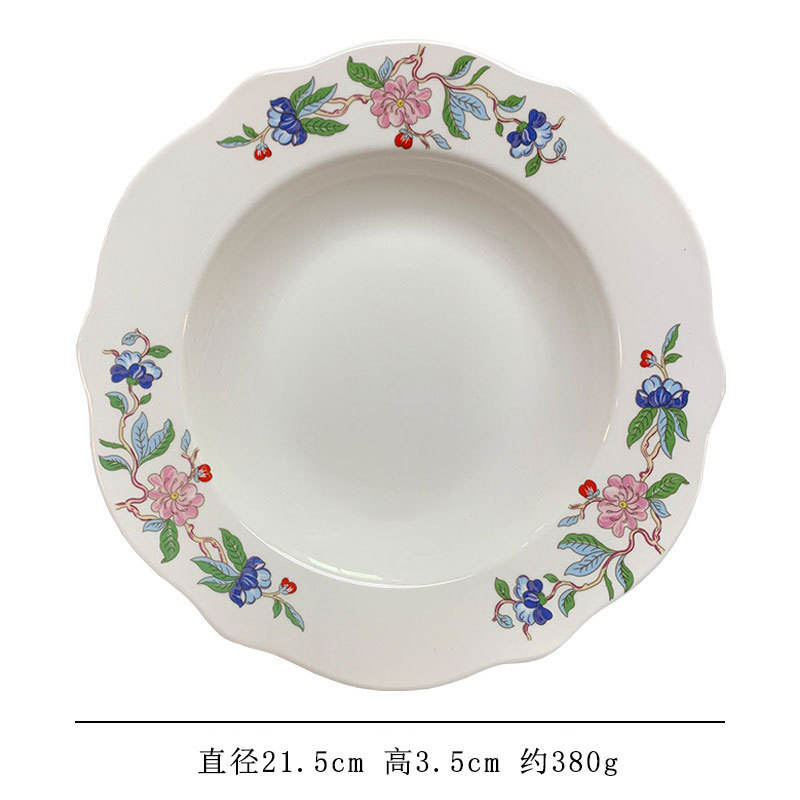 Assiette creuse blanche à volants, motif fleurs et oiseaux.