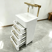 Chariot de rangement roulant de luxe moderne blanc crème avec poignées dorées et 4 roues robustes pour outils de coloration capillaire d'hôtel et de salon