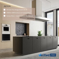 Ensemble d'armoires de cuisine en bois clair et gris foncé avec grand îlot central, four encastré, coin encastré et crédence en pierre pour villa