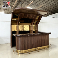 Comptoir de bar de luxe sur mesure, design incurvé, en noyer cannelé, avec dessus en marbre foncé, marchepied, capot LED, armoire, mobilier pour club et restaurant