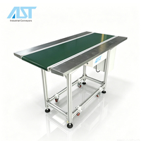 Convoyeur à bande pour ligne d'assemblage robuste AST avec cadre en aluminium et tables en acier inoxydable des deux côtés pour postes de travail manuels