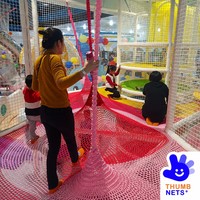Structure de grimpette intérieure multi-niveaux en filet blanc avec poteaux rembourrés et plateformes colorées – Équipement commercial pour centre de jeux pour enfants
