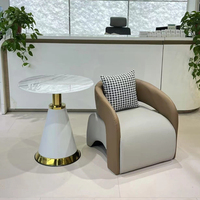 Fauteuil lounge et table basse en cuir, style minimaliste moderne, robustes et durables, adaptés à l'utilisation dans les hôtels et les salons.