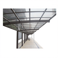 Auvent de stationnement contemporain en acier avec entrée en façade vitrée et caractéristiques en verre