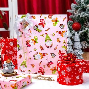 Papel de regalo navideño de doble cara con diseño de Papá Noel, gnomos y copos de nieve en colores rosa y rojo, en papel estampado. - Product Image 1