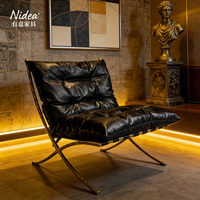 Fauteuil lounge moderne de style mid-century, en cuir noir vieilli fait main, avec structure en X dorée antique, pour salon, club ou bar