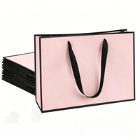 Des arcs roses décorent le sac en papier d'emballage écologique de demoiselle d'honneur de luxe au détail Portable Boutique pour le magasin de vêtements
