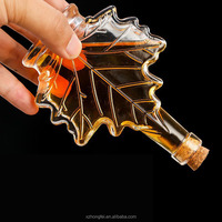 Vente en gros Bouteille de boisson en verre unique de haute qualité en forme de feuille d'érable Capacité de 50ml 100ml 250ml Bouchon de liège