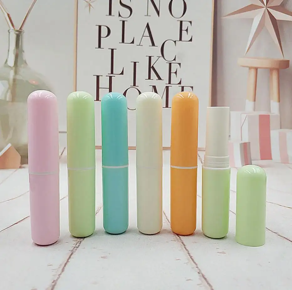 Vente en gros de tubes de baume à lèvres vides en plastique en forme de pilule avec logo personnalisé tubes de rouge à lèvres rose bleu orange beige vert conteneurs