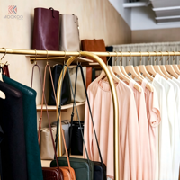 Porte-vêtements en métal doré incurvé avec base en bois clair, support de présentation pour vêtements, présentoir pour boutique de vêtements, pour magasin de vente au détail