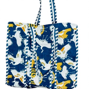 Bolso de mano de algodón con elegante diseño de vuelo de grullas, fondo azul índigo, detalles vibrantes en amarillo y elegantes rayas - Product Image 1