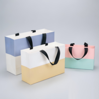 Sac en papier cartonné blanc imprimé sur mesure, vente en gros d'usine, avec poignée en ruban, idéal pour l'emballage de vêtements en magasin de détail