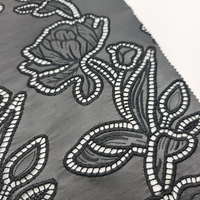 Tissu en cuir PU perforé brodé à découpe laser noire à motif floral abstrait pour manteau et textile de maison