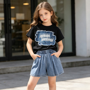 Set Abbigliamento <span class=keywords><strong>Bambina</strong></span> Estate 2026: T-shirt Nera con Patch a Maniche Corte + <span class=keywords><strong>Pantaloncini</strong></span> in Denim, Completo 2 Pezzi - Product Image 1
