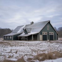 Grange d'hiver verte avec plusieurs sections de toit, aération par coupole, entrée couverte et cour de ferme enneigée