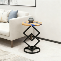 Table d'appoint ronde en bois d'olivier naturel et résine époxy avec base géométrique en métal pour le salon et la chambre à coucher.