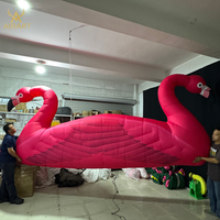 Comptoir de bar gonflable flamant rose décoré pour festivals et mariages, avec plumes réalistes. Montage facile, oiseau gonflable pour exposition en bord de lac.