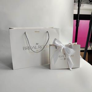 Sac en papier mat de luxe avec logo personnalisé en feuille d'or pour l'emballage de bijoux, cosmétiques et lunettes, avec nœud en ruban - Product Image 1