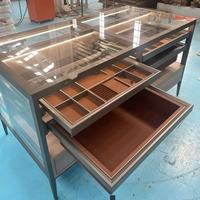 Vitrine d'îlot à bijoux moderne haut de gamme sur mesure, autoportante, en verre trempé, avec rangement suspendu compartimenté pour salon