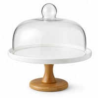 Support à gâteau rond blanc surélevé avec bordure conique en bois, dôme en verre transparent et bouton sphérique pour présentation sur table à manger
