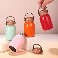 Bouteille isotherme mini ronde en acier inoxydable avec couvercle effet bois et poignée de transport en silicone pour voyage (vente en gros)