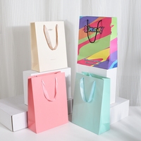 Cadeau de luxe de haute qualité à utiliser en magasin Sacs d'emballage en papier personnalisés avec logo imprimé pour vêtements avec corde à ruban