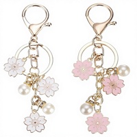 Porte-clés pendentif en alliage « Twin Flowers » le plus vendu, avec petite fleur blanche mignonne, lettre et perle, accessoire pour étui d'écouteurs ou sac, modèle à suspendre