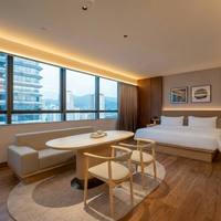 Ensemble de chambre d'hôtel moderne avec tête de lit capitonnée, lit king size, banc de fenêtre en bois clair et ensemble de salon, qualité commerciale pour appartement
