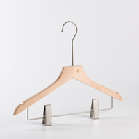 Cintres en bois massif naturel avec logo personnalisé, rainures en U et pinces métalliques rembourrées pour pantalons, jupes et présentation en boutique