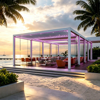 Pergola bioclimatique commerciale sur mesure pour bord de mer avec toit à lames motorisées, éclairage RGB et verre sans cadre