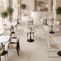 Tables blanches de style minimaliste et chaises rembourrées douces, mobilier commercial pour pâtisserie et café
