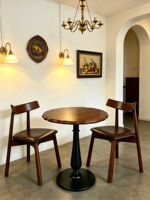 Table ronde vintage en bois massif pour deux personnes avec pieds en fer forgé et chaises en cuir PU pour cafés, bars et hôtels
