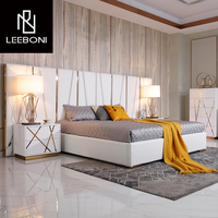 Lit rembourré moderne de luxe en cuir blanc avec garniture dorée, ensemble de meubles de chambre avec table de chevet et armoire pour la maison